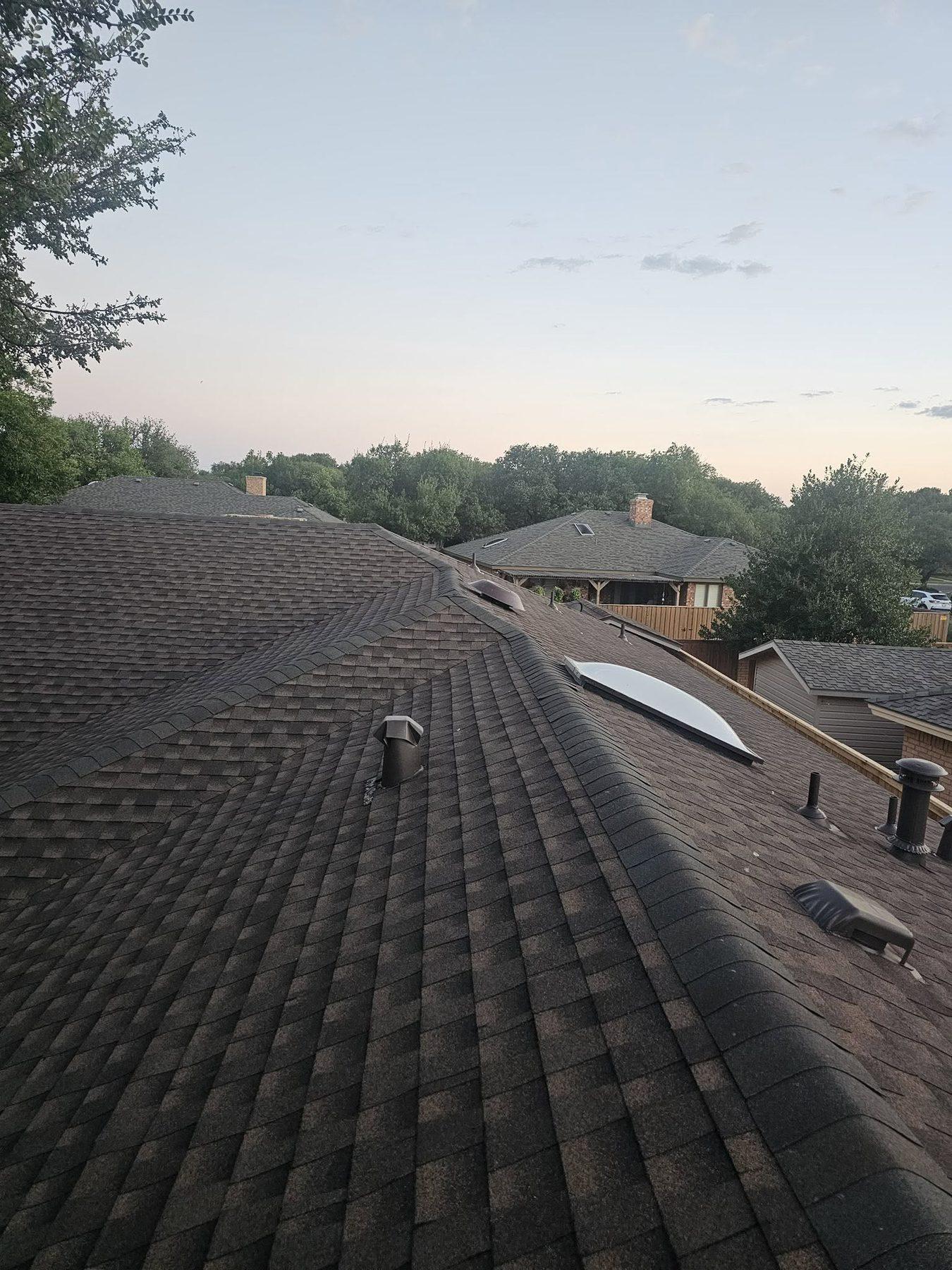 A finished architectural shingle roof at dusk