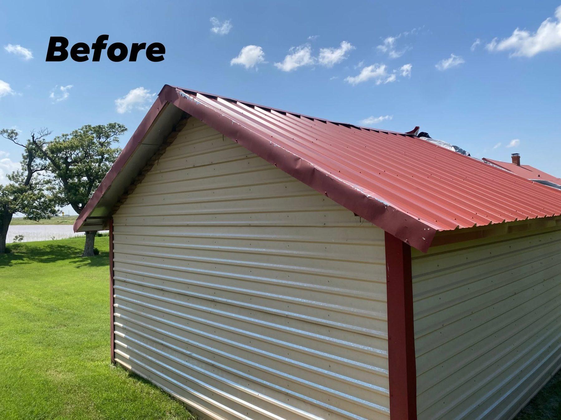 A barn with storm-damaged red metal roofing before repair