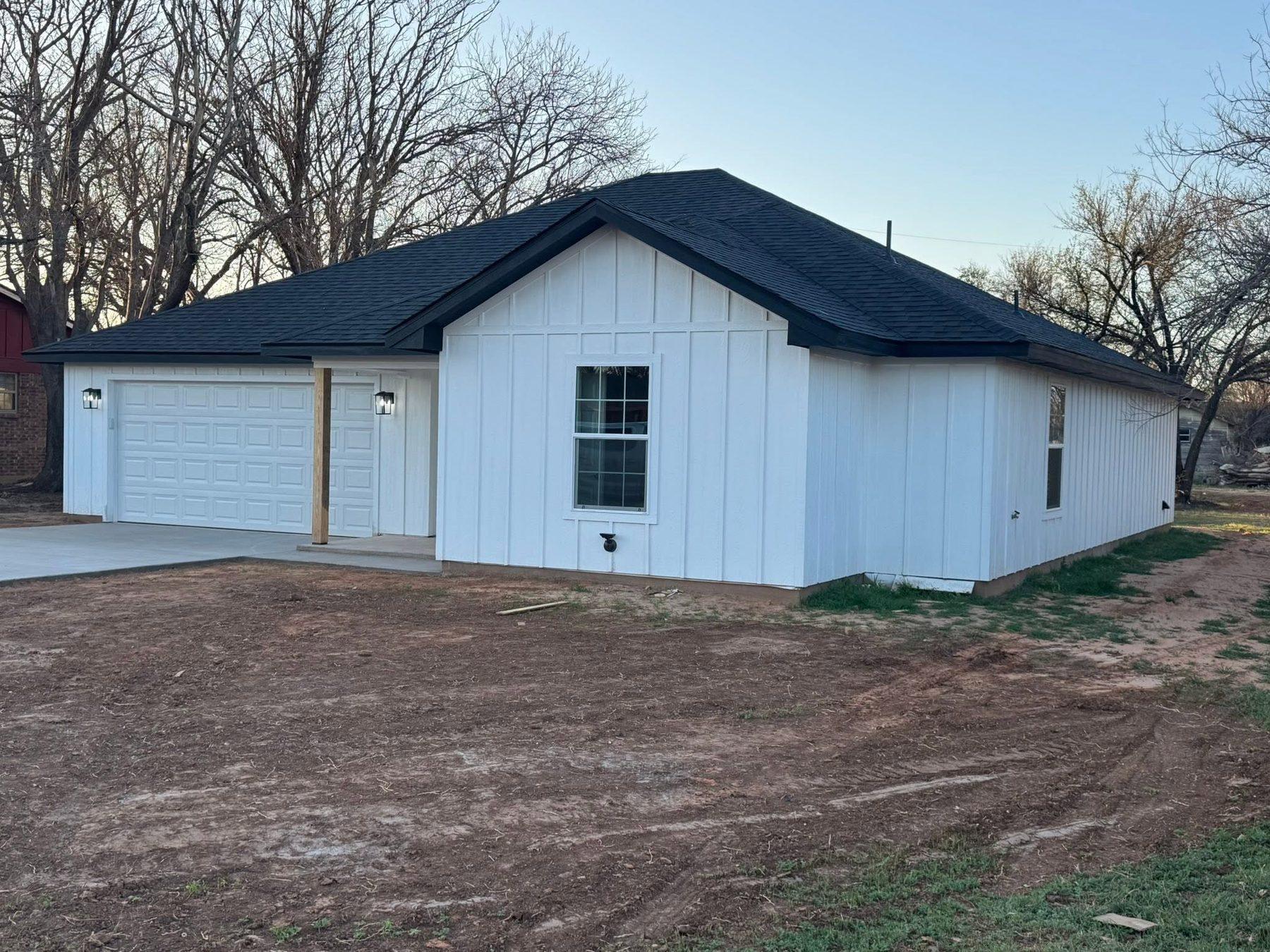 A newly finished white home with an attached garage
