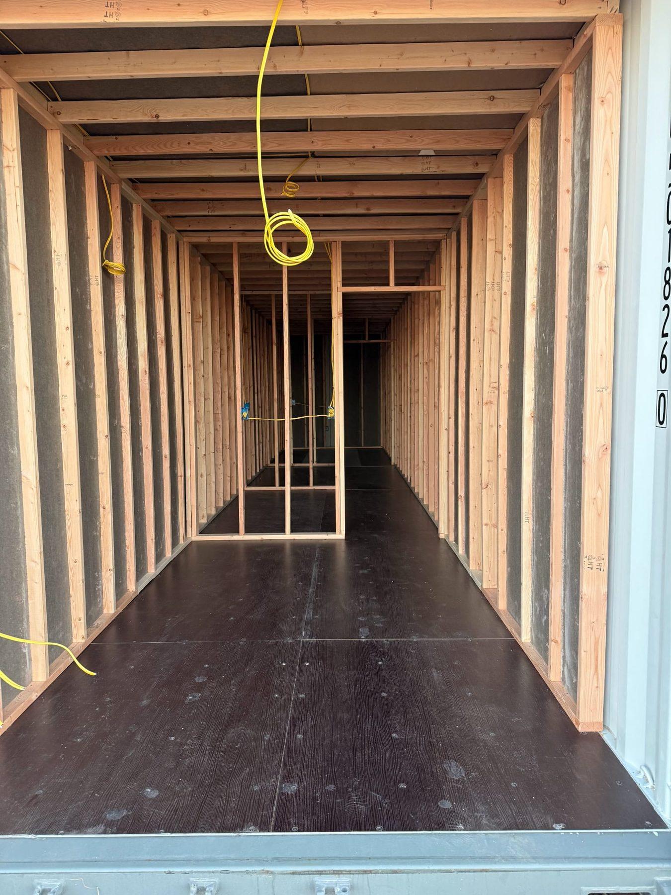 Wood stud framing inside a shipping container during build-out