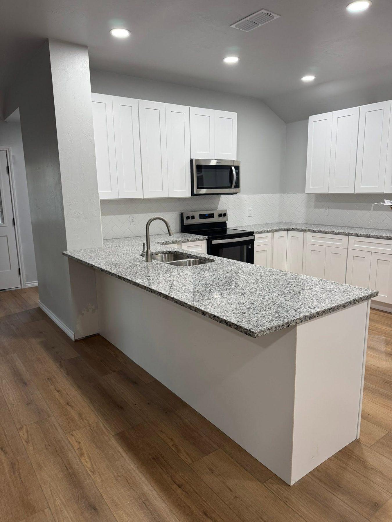 Finished white kitchen with granite counters and stainless appliances
